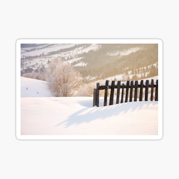 wooden fence in snow and morning sunlight Sticker