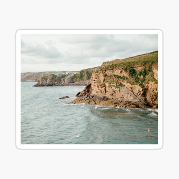 Powerful Ocean Waving Near Rocky Cliffs Under Cloudy Sky Sticker