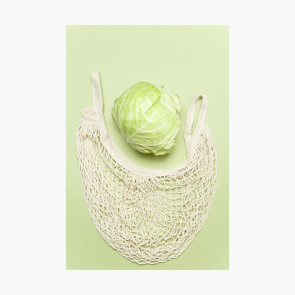 Trendy string bag with fresh young cabbage over light green background. Zero waste sustainable lifestyle concept. Photographic Print