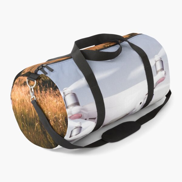 Item preview, Close up of hovering drone taking pictures of green meadows and hills at sunset designed and sold by TravelDrone.