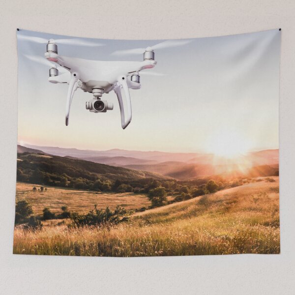 Item preview, Close up of hovering drone taking pictures of green meadows and hills at sunset designed and sold by TravelDrone.