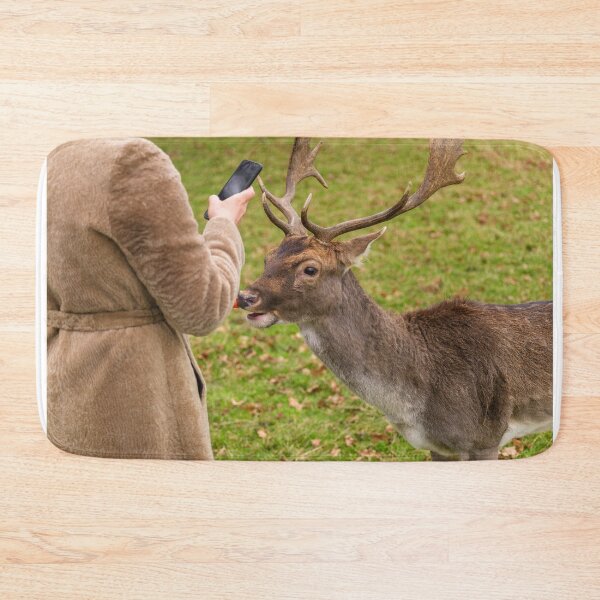Item preview, A woman is photographing a portrait of a friendly deer in Phoenix Park, Dublin, Ireland designed and sold by AlbertMi.