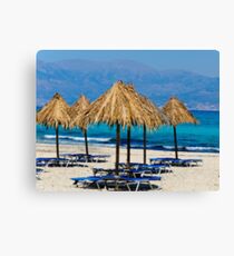 Sunbeds and umbrellas on the beach Canvas Print