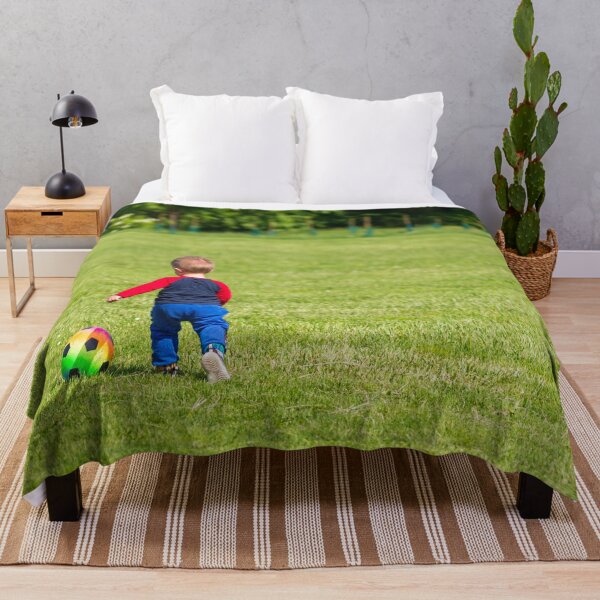 Item preview, A child plays with a colorful ball on a green lawn designed and sold by brambillasimone.