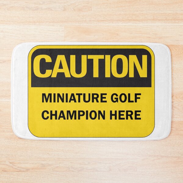Item preview, Caution: miniature golf champion here warning saying with yellow and black typography designed and sold by Deegital18.