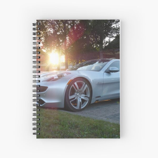 2012 Fisker Karma electric supercar against a sunset Spiral Notebook