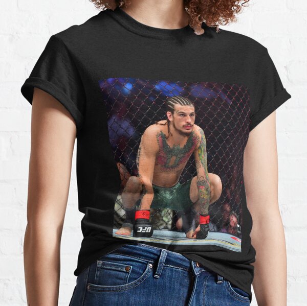 Un hombre en un ring de boxeo con un hombre con un pantalón corto blanco y  una camiseta que dice boxer.