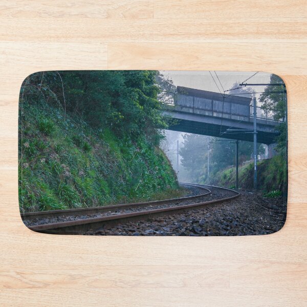 Item preview, Lonely train tracks disappearing under a bridge and into a foggy morning landscape designed and sold by James-Cole.