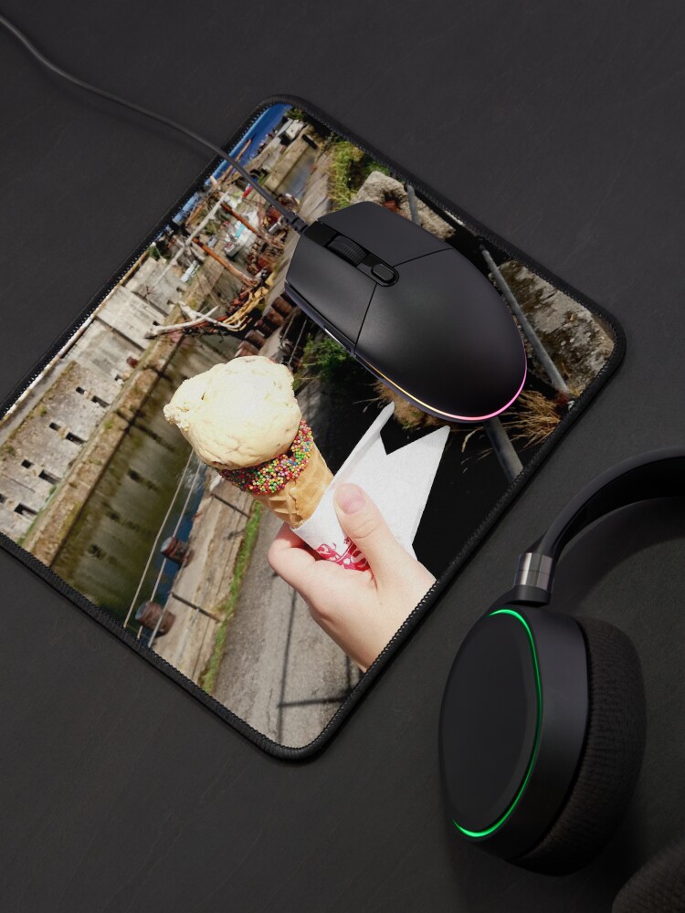 Alternate view of Person holding an ice cream cone near a sailboat and an old building, sunny day with clouds in the sky Mouse Pad