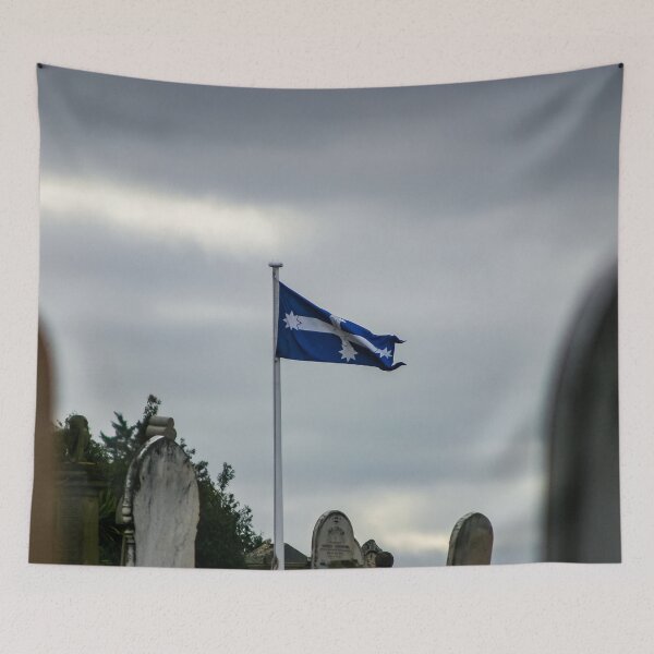 Item preview, Eureka flag flying in the wind on a gloomy overcast day in the old Ballarat cemetery designed and sold by James-Cole.