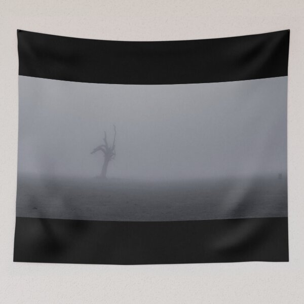 Item preview, Creepy silhouette of dead tree stump stands alone in a foggy field designed and sold by James-Cole.