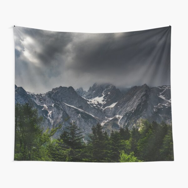 Stormy skies above mountains and spring forest Tapestry