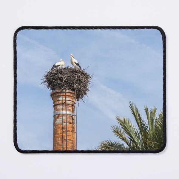 Item preview, Bringing Babies - White Storks Nesting on a Tall Brick Chimney Above the Treetops designed and sold by Georgia Mizuleva.