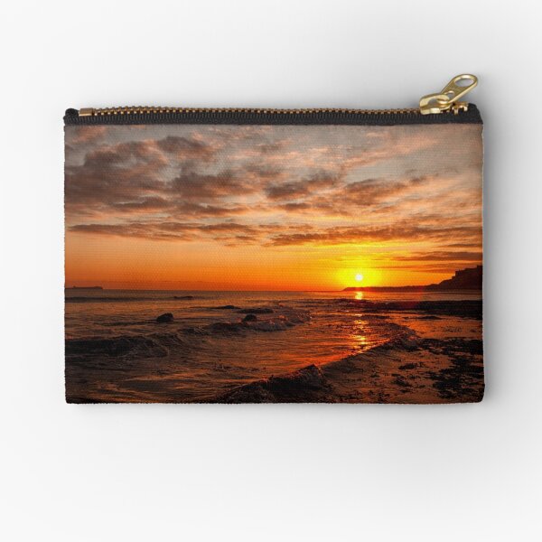 Sunrise across the waves to Bamburgh Castle, Northumberland, UK Zipper Pouch
