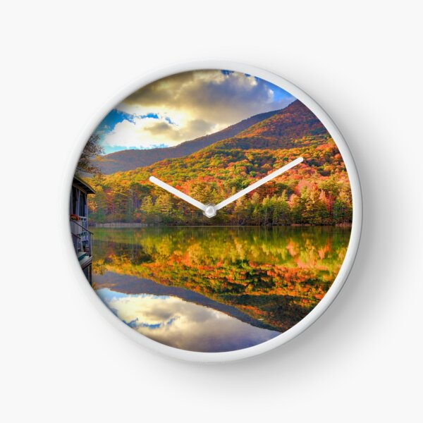 Reflection in water near house with mountain Clock