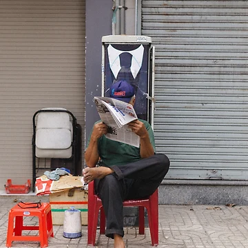 Vorschaubild zum Design man in green t-shirt reading book sitting on red plastic chair von buucake