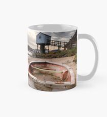 Old red rowing boat on the beach with lookout tower Mug