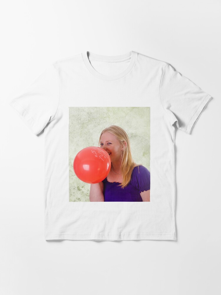 Young woman blowing red balloon