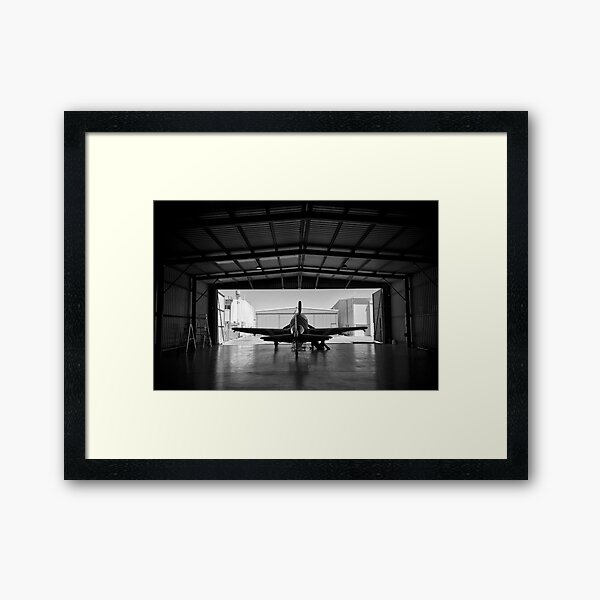 Silhouette of a P-51 Mustang fighter aircraft in a hangar Framed Art Print
