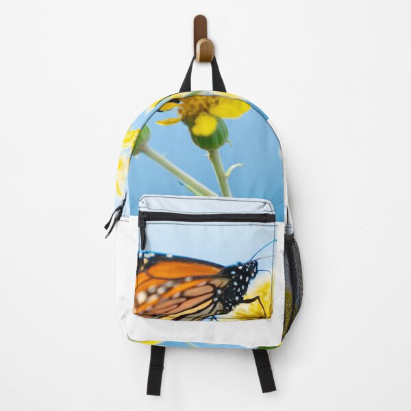 Item preview, Monarch butterfly resting on yellow daisy against sky background. designed and sold by Brian Scantlebury.