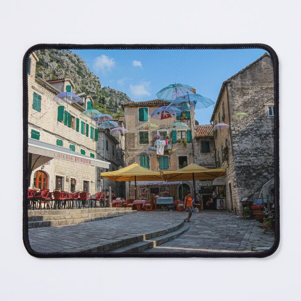 Item preview, Cafe's and flying umbrellas on a square in the old town of Kotor, Montenegro designed and sold by SnapTPhotograph.