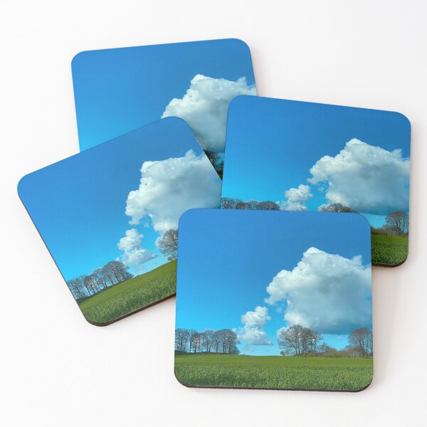 Item preview, Puffy white cloud in a blue sky with trees on a green hill on Rügen Island, Germany designed and sold by Michael Brewer.