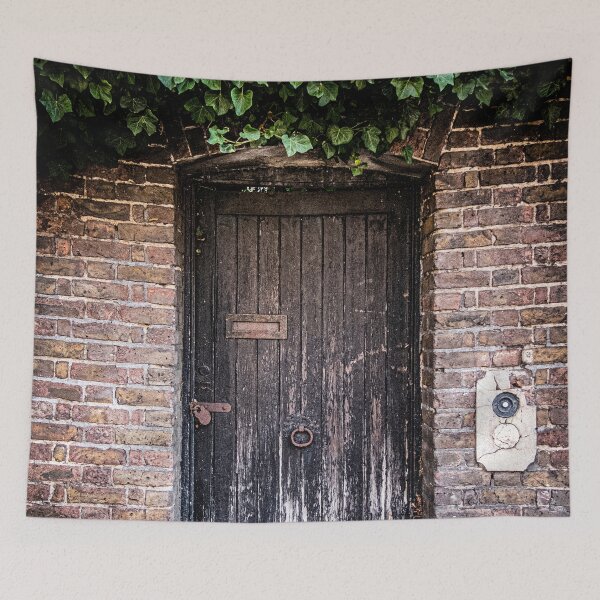 Item preview, Photo of a weathered door covered in green ivy to a secret garden in London designed and sold by Diana van Neck.