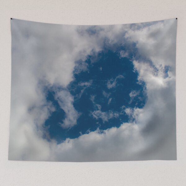 Item preview, A hole through thick fluffy white clouds showing the deep blue sky behind designed and sold by James-Cole.