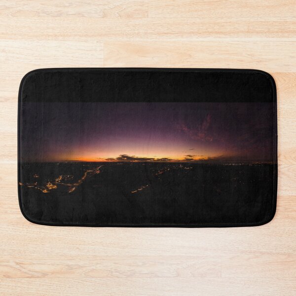 Item preview, Dark horizon clouds in a deep purple sky in the afterglow of an golden sunset above the street lights aerial panoramic designed and sold by James-Cole.