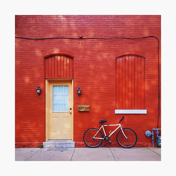 a white bicycle leaning against a red wall Photographic Print