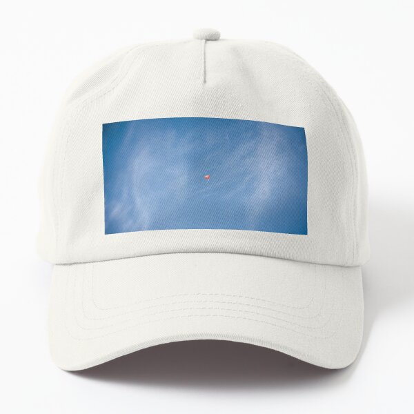 Small red heart air balloon flies high up in the blue sky with white veil clouds Dad Hat