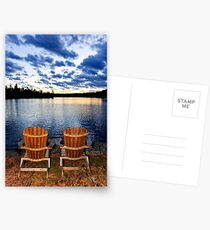 Wooden chairs at sunset on lake shore Postcards