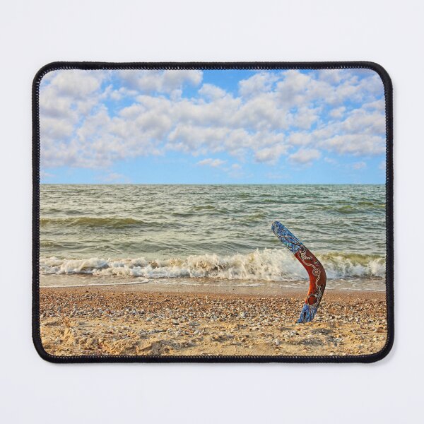 Item preview, Multicolored Australian Boomerang on sandy beach against of sea surf and sky. designed and sold by IaroslavB.