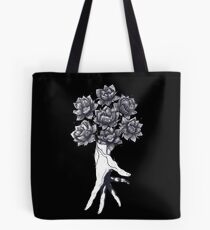 Hand with lotuses on black Tote Bag
