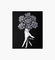 Hand with lotuses on black Art Board
