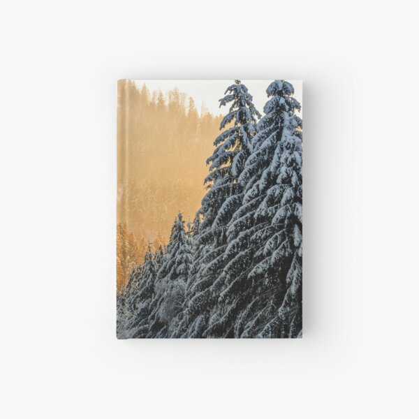 snowy road through spruce forest at sunset Hardcover Journal