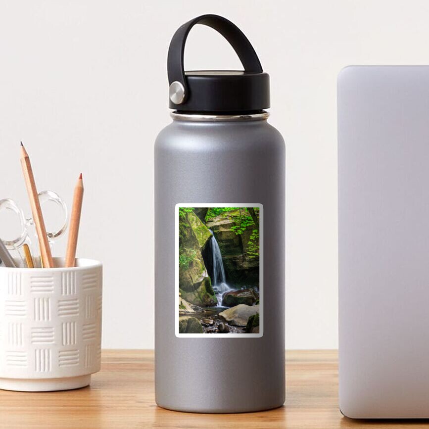 waterfall comes out of a huge stone in forest Sticker