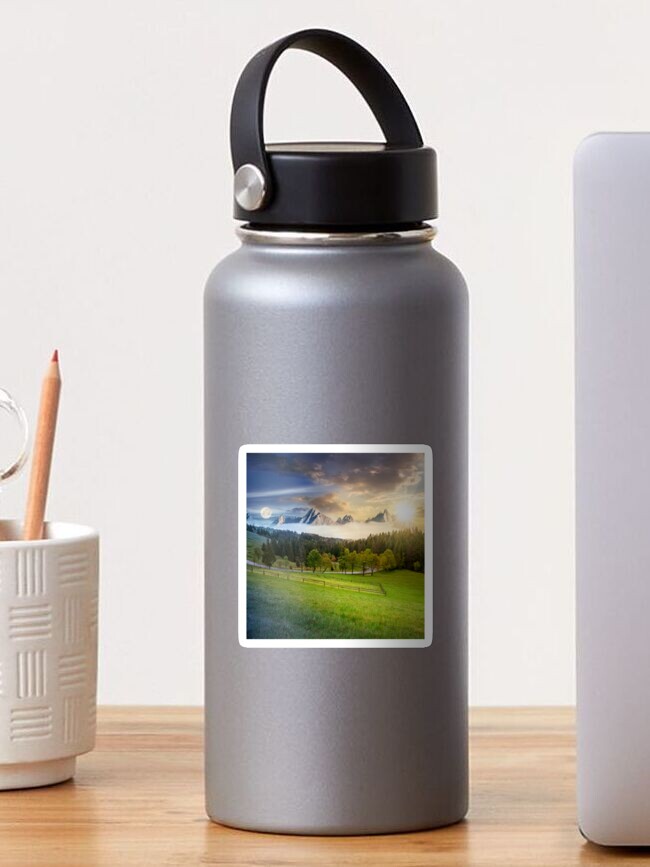 Thumbnail 1 of 3, Sticker, day and night above rocky peaks behind the forest and meadow designed and sold by mike-pellinni.