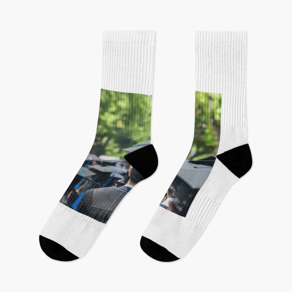 Item preview, Classmates walking on campus boulevard graduating with bachelor caps background at dusk designed and sold by zenger2021.