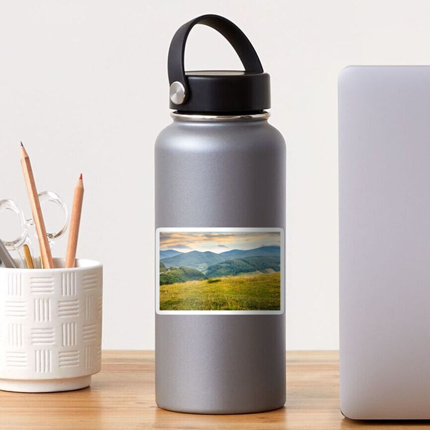 grassy meadow in mountains at sunrise Sticker