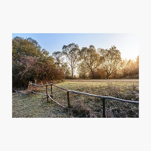 wooden fence in fog on frozen meadow at sunrise Photographic Print