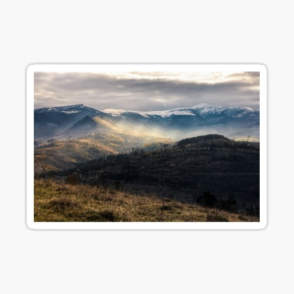 snowy peaks over hillsides in fog Sticker