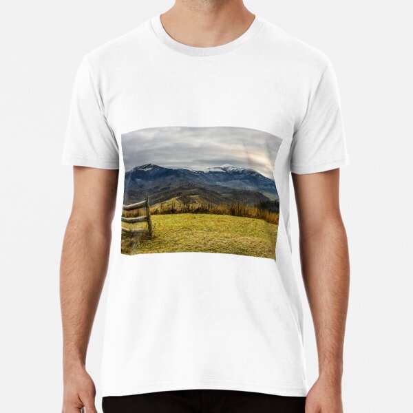 fence on the meadow in snowy mountains Premium T-Shirt