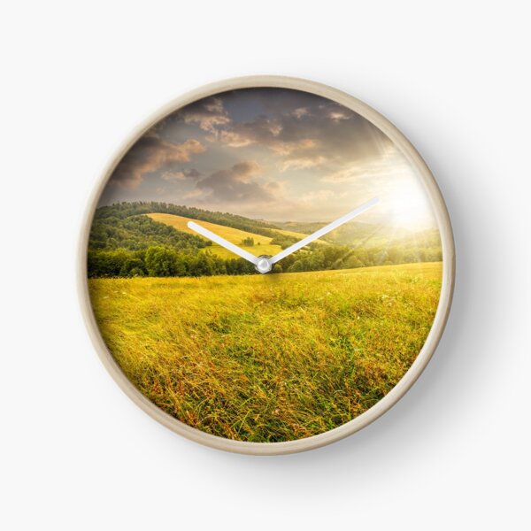 rural field near forest at hillside at sunset Clock