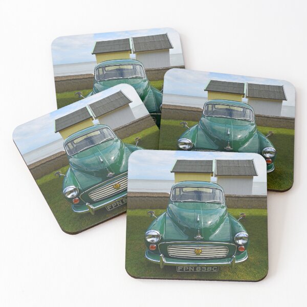 Item preview, Classic Green Morris Minor with AA Badge parked with beach huts and ocean in background. designed and sold by Umdash919.