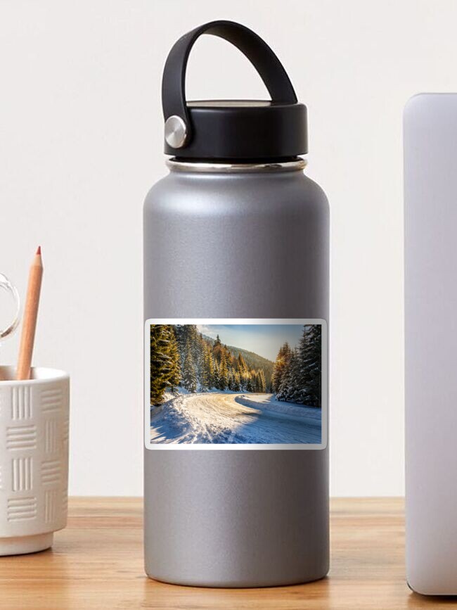 Thumbnail 1 of 3, Sticker, snowy road through spruce forest in mountains designed and sold by mike-pellinni.