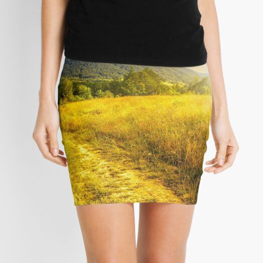 road through a rural meadow on the hillside at sunset Mini Skirt