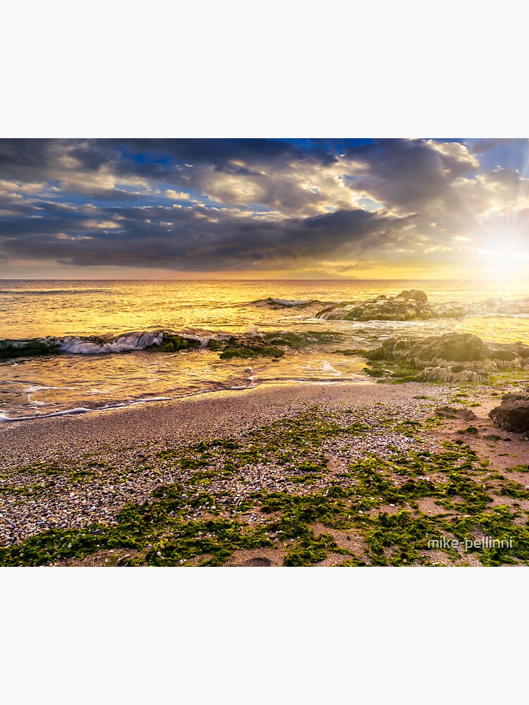 sea shore with stones after the storm at sunset by mike-pellinni
