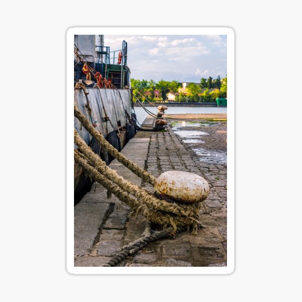 Boat docked to a mooring bollard in the port of Sozopol at sunset Sticker