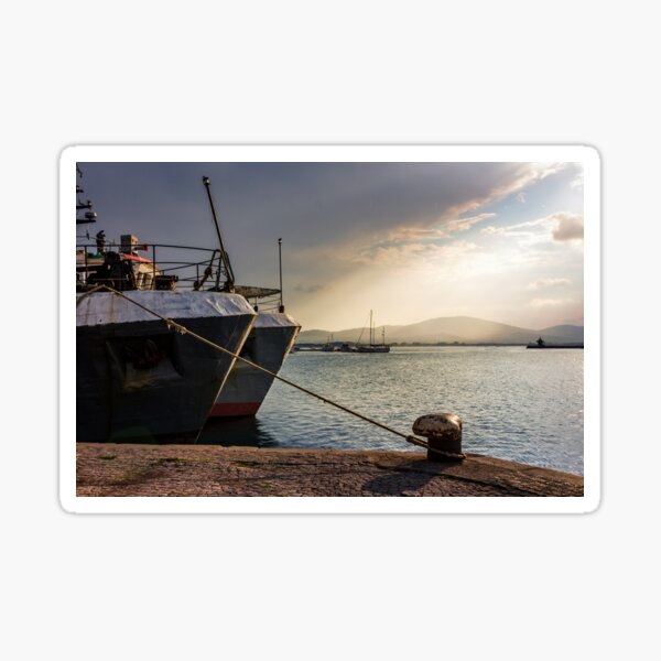 Boats docked to a mooring bollard in the port of Sozopol at sunset Sticker